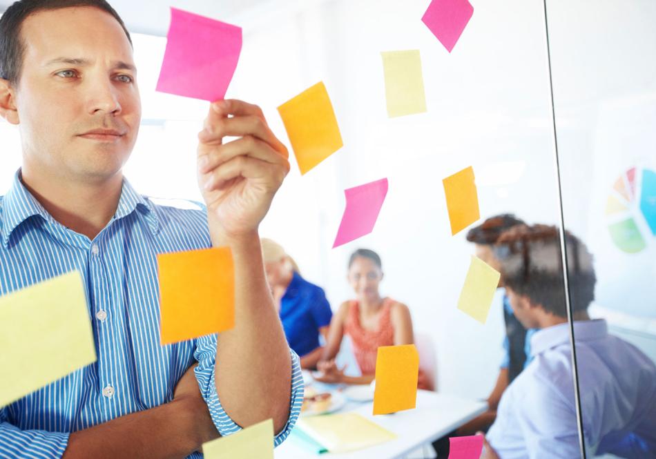 mies pitää post-it lappuja