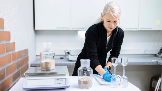 Laatuassistentti Arja Salo mittailee  ainesosia laboratoriossa.