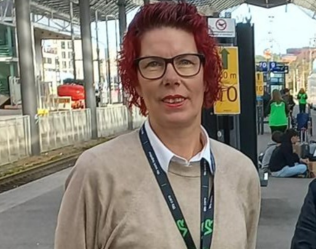 Ann-Mari Ahonen ja Helena Tikka seisovat rautatieasemalla. heidän takanaan on juna ja junaraide.