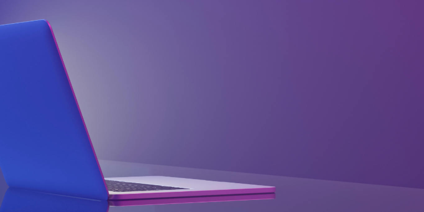 Kuvassa kannettava tietokone violettia taustaa vasten