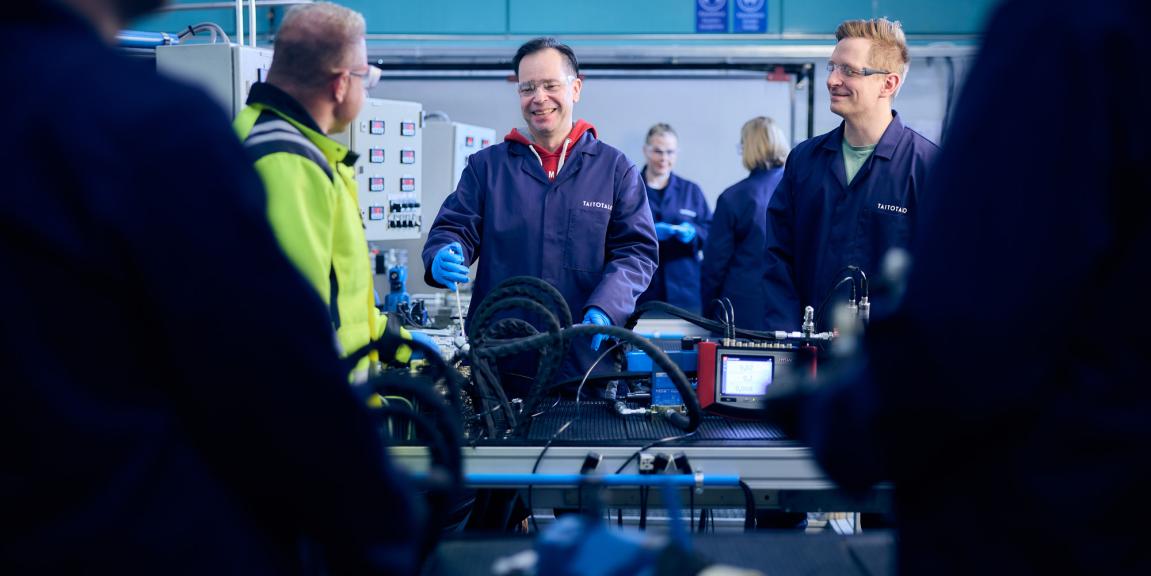 Oppilaita tekemässä harjoituksia hydrauliikkatyötilassa.