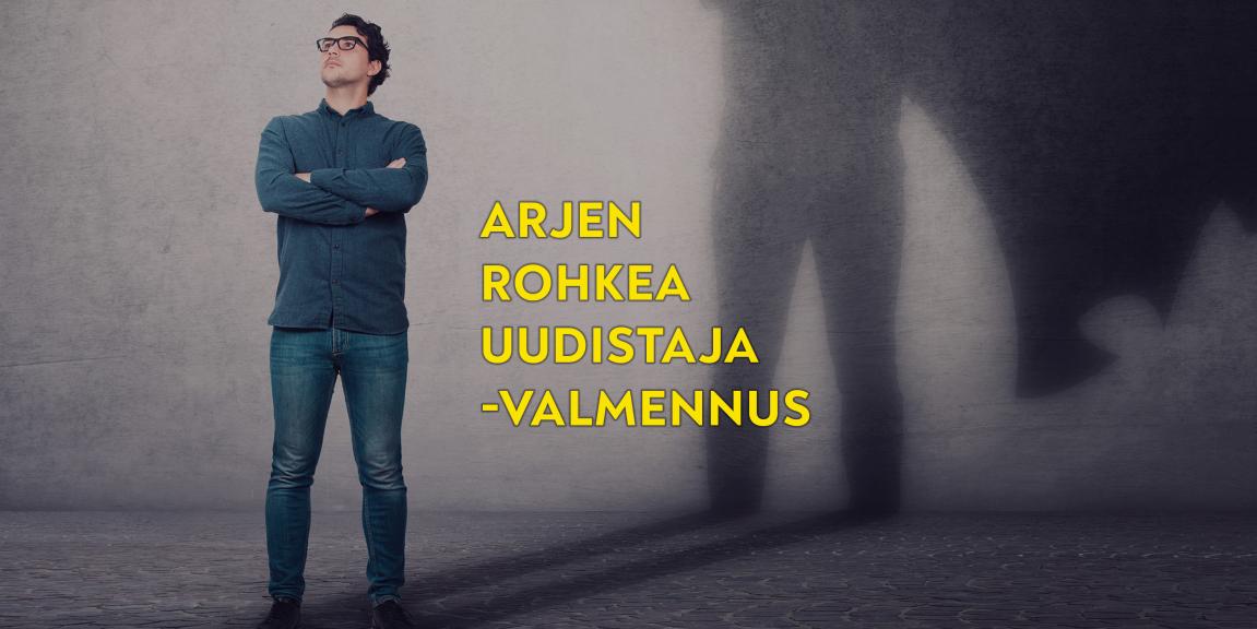 Mies seisoo kädet puuskassa, varjolla sankarin viitta