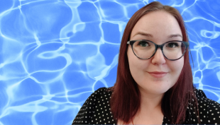Artikkelin kansikuva, jossa Sandra Heinaste on kuvan oikeassa laidassa. Kuvassa on sininen tausta ja Sandralla on musta jakku ja punaiset hiukset.